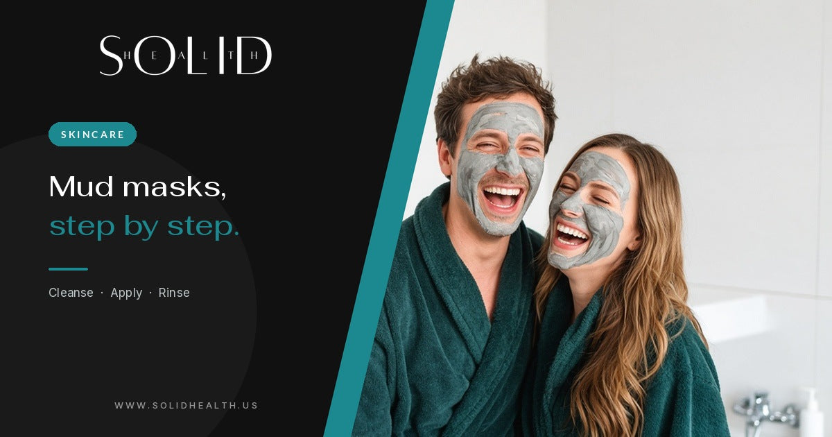 Couple in green robes laughing while wearing grey mud masks